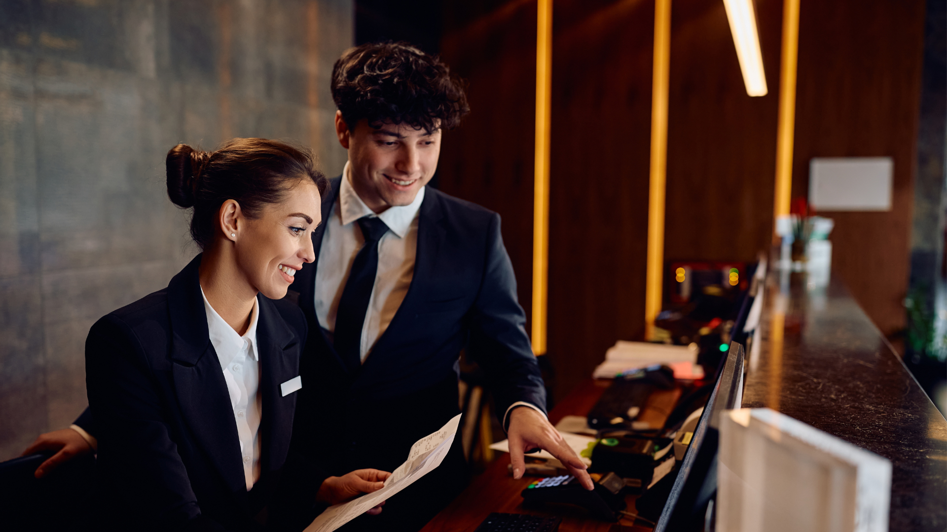 Two colleagues reviewing work together at a reception desk